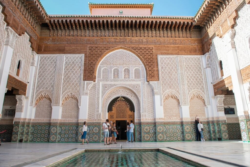 A group of people standing around a pool in a building imperial cities tour morocco