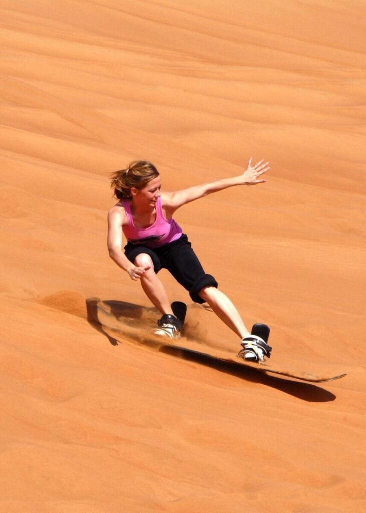 sandboarding in Erg Chebbi dunes Merzouga Sahara desert Morocco